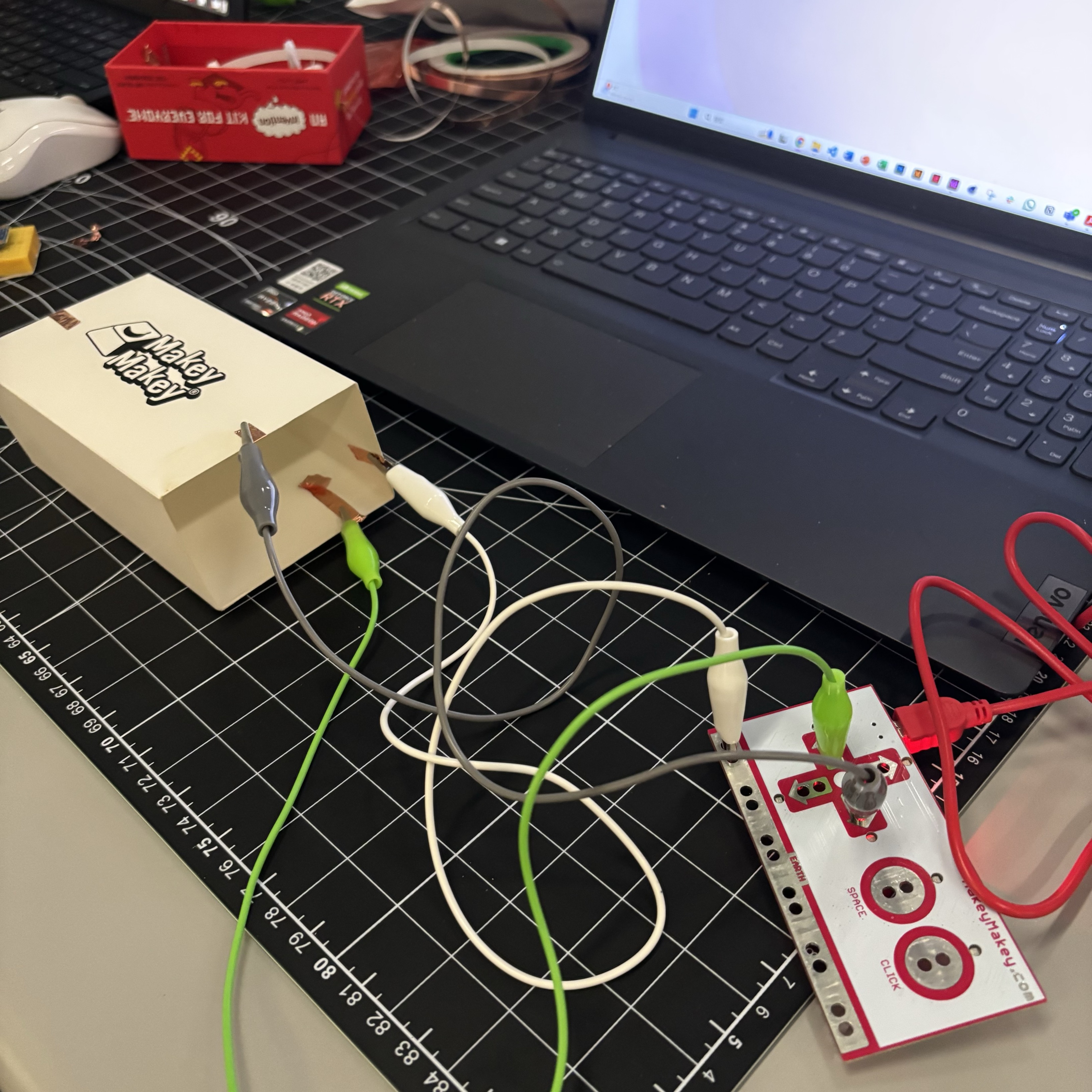 Building on that idea, I added an extra strip of copper tape so that users can trigger different keys depending on the direction in which they press the box.