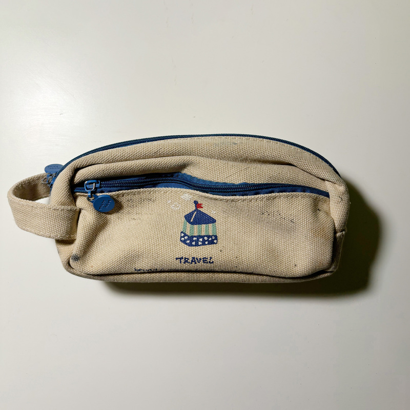 A front view of a pencil bag, similar to a cube or cylinder. Its soft texture makes it a complex object.