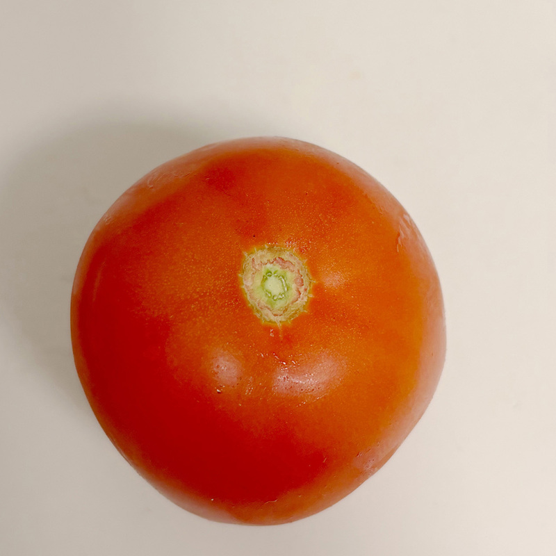 Top view of a tomato. You can see that there is an indentation at the top of the tomato and the color of this indentation is different from the color of the tomato, which can be difficult when modeling.