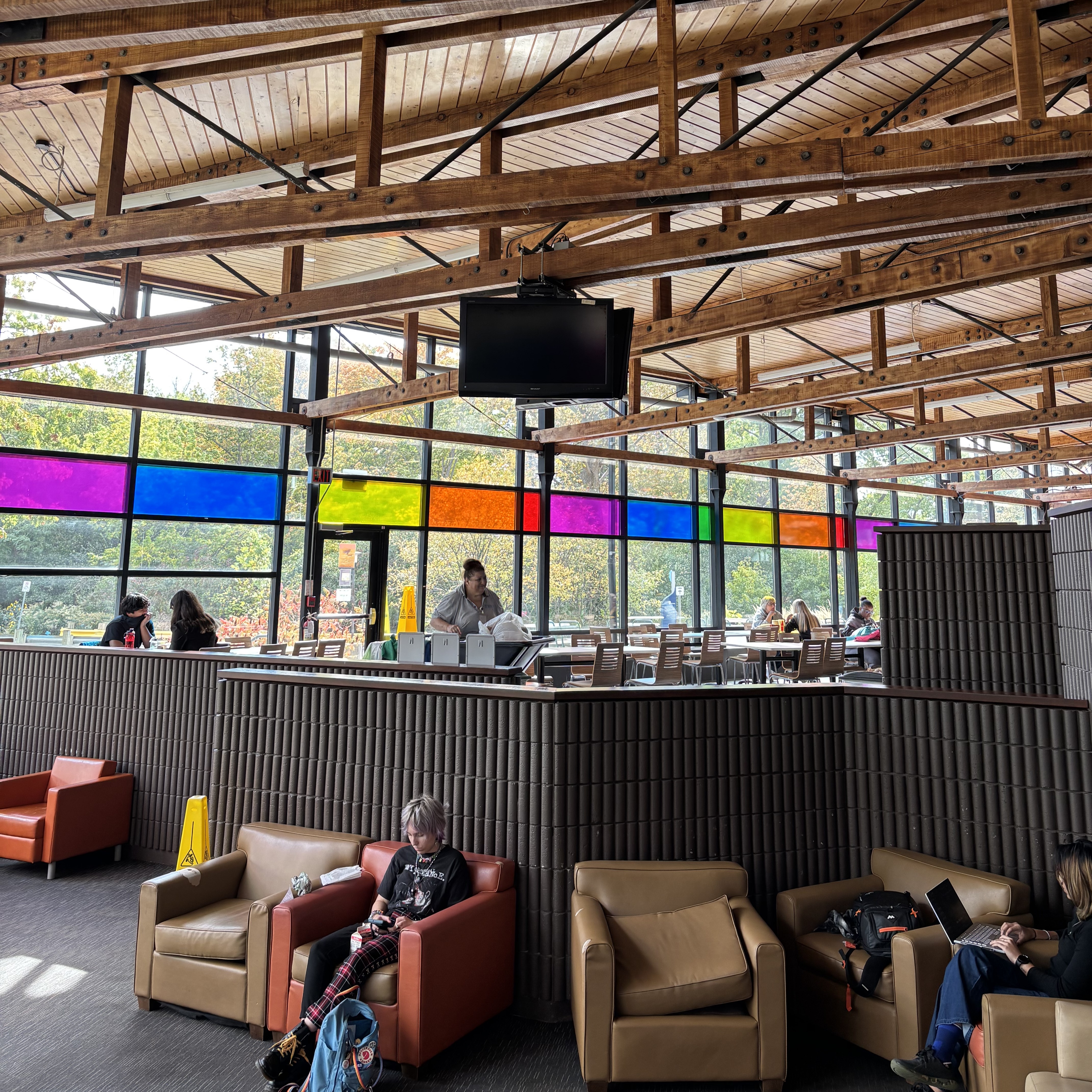Our school cafeteria has always been one of my favorite places. The designers used colorful glass, which makes it especially eye-catching when there is sunlight. And as a place for people to rest and eat, the large amount of logs can make people feel relaxed and calm. Meanwhile, the split-level design of the cafeteria effectively separates the dining area from the lounge area, so whether you're lounging alone or dining with friends, you won't feel awkward or disturbed.
 